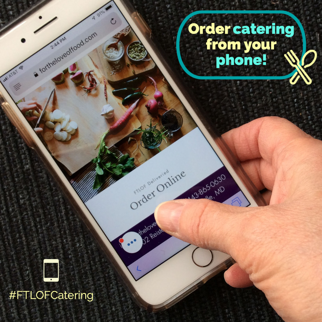 A hand holding a cellphone and ordering catering online.